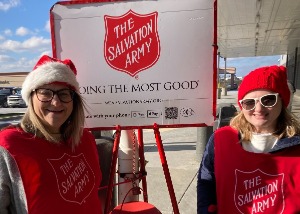 Two CHROME employees ringing the bell at Salvation Army red kettle